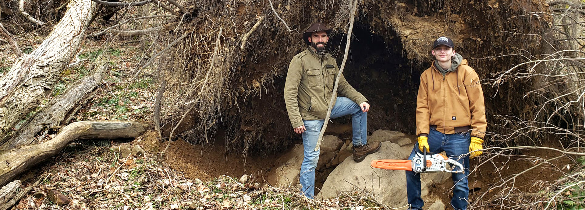 Slideshow Image - Two staff members with a chainsaw beside a downed tree